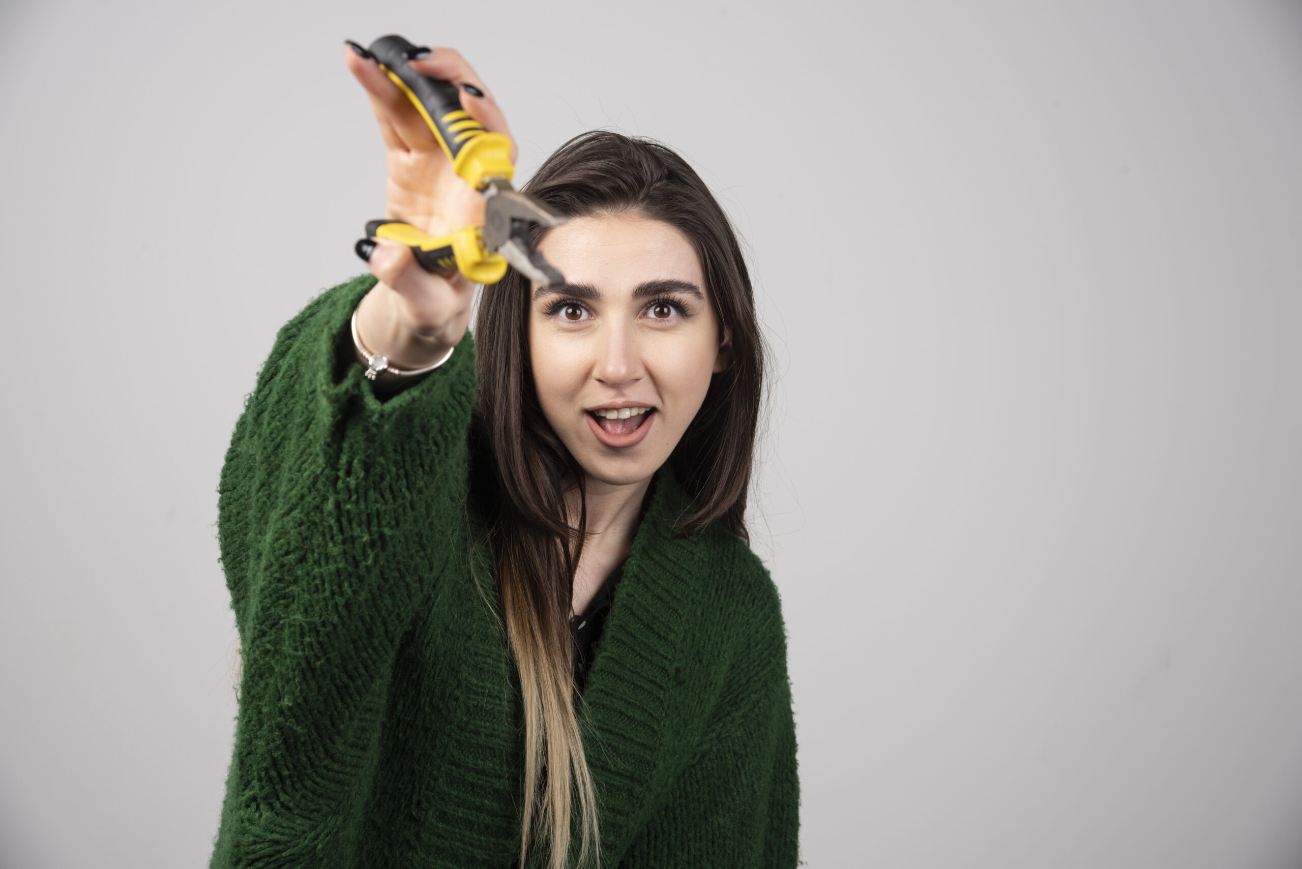 a beautiful young girl holding pliers in her hands