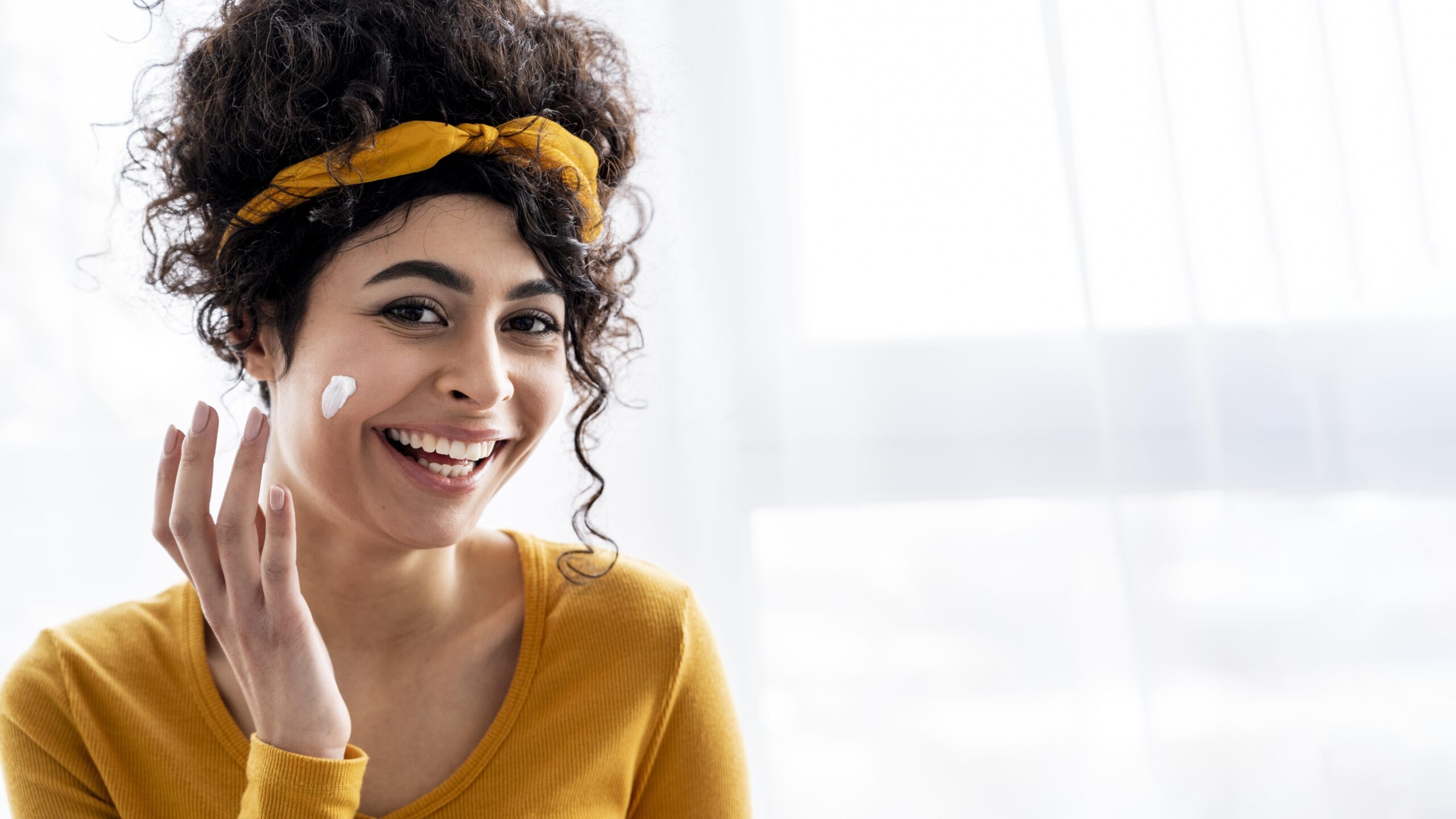 portrait happy woman laughing playing with moisturizer with copy space